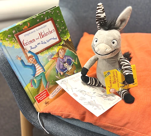 Abbildung der Gewinnspielpreise: Zesel-Stofftier, das Buch Grimm und Möhrchen - Besuch von Tante Camembert, ein Stickerbogen und Zesel-Pflaster